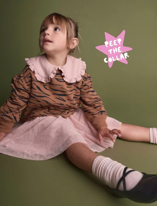 toddler girl in tiger print sweatshirt with pink collar