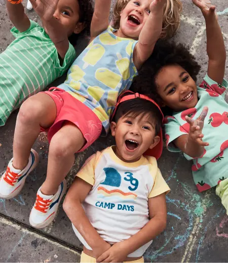 kids laying on the ground in summer staples collection