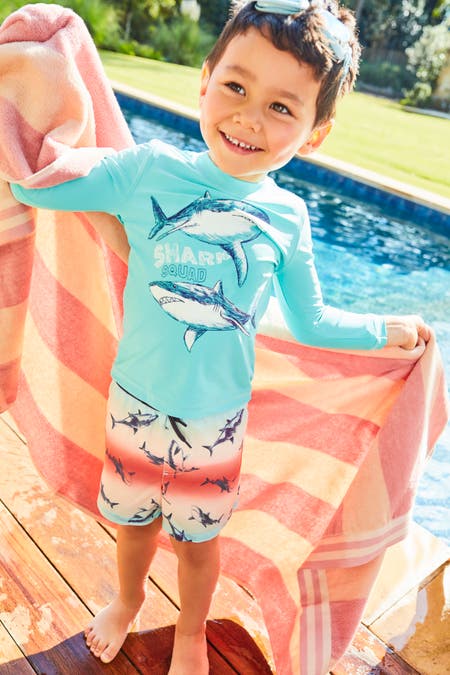 Kid with a towel at water park