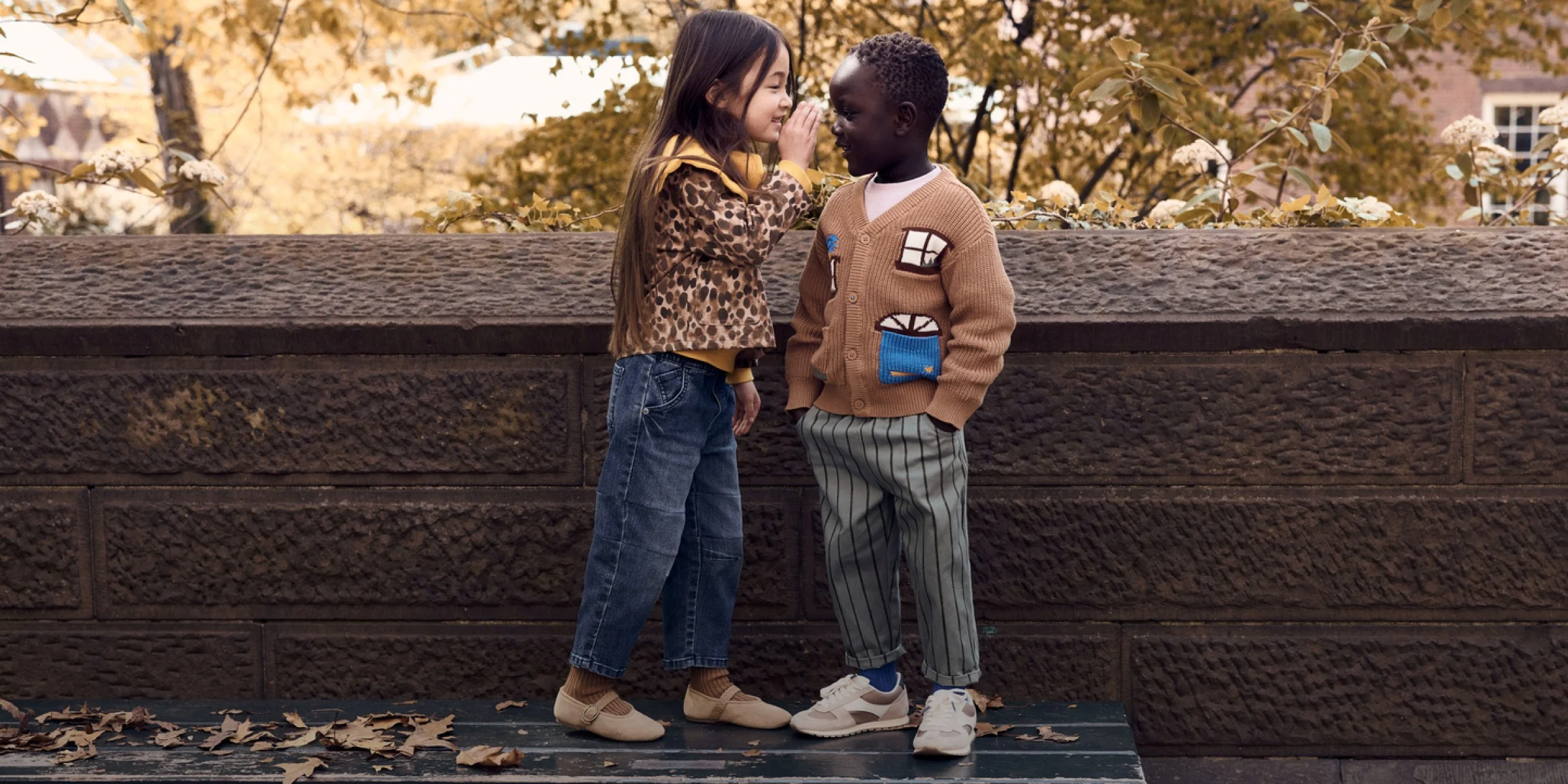 two kids standing on park bench