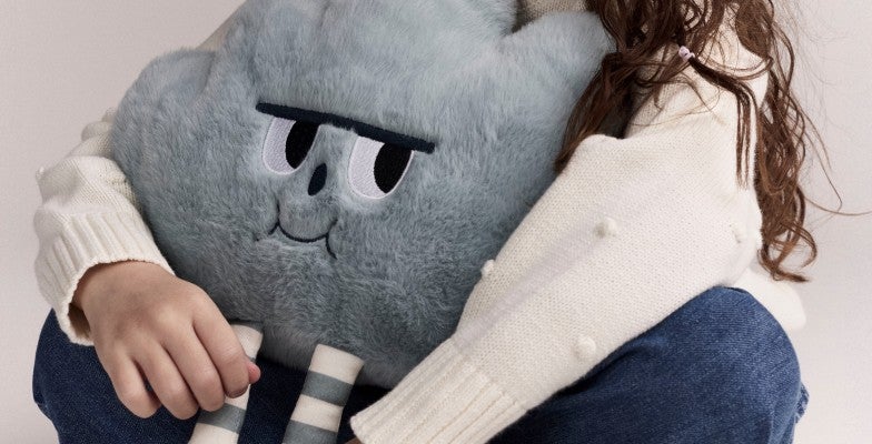 girl holding a cloud stuffed toy