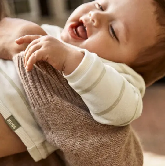 baby being help by mom in a striped daydream fleece top