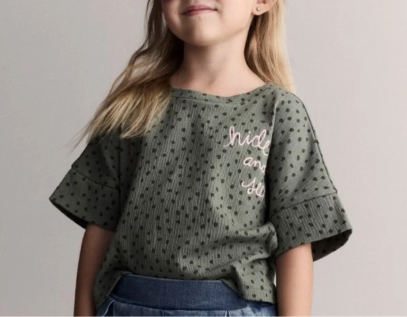 toddler girl in green polka dot top
