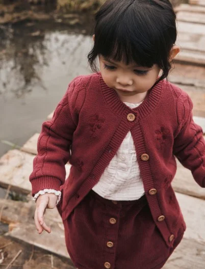 toddler girl in sweater and skirt