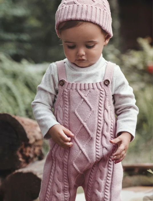 baby girl in knit overalls