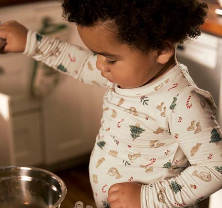 baby mixing cookies in christmas pajamas