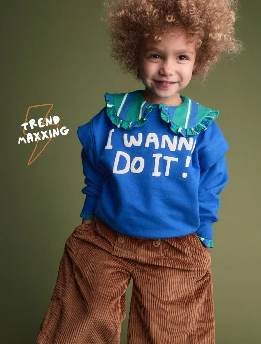 toddler girl in blue graphic sweatshirt and striped collar