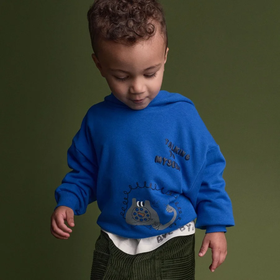 toddler boy in blue graphic hoodie